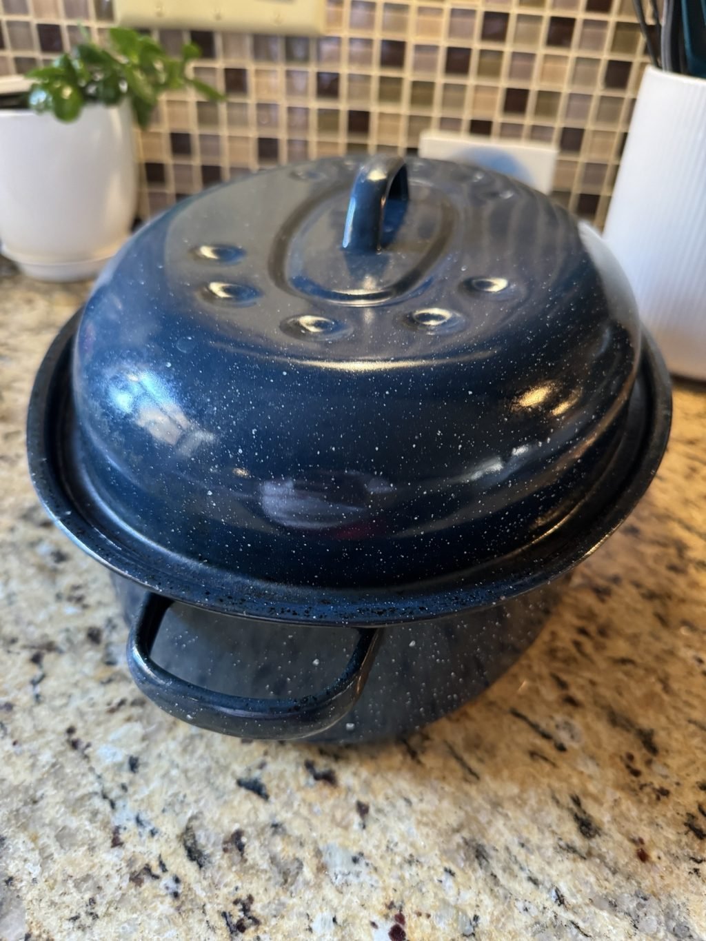 A blue speckled roaster on a kitchen counter