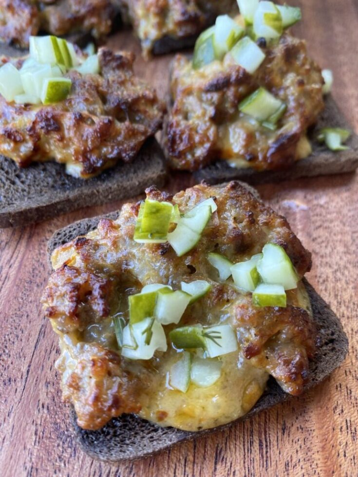 mini rye bread slices with ground pork sausage crumbled on top, velveeta cheese melted in with onions and pickles