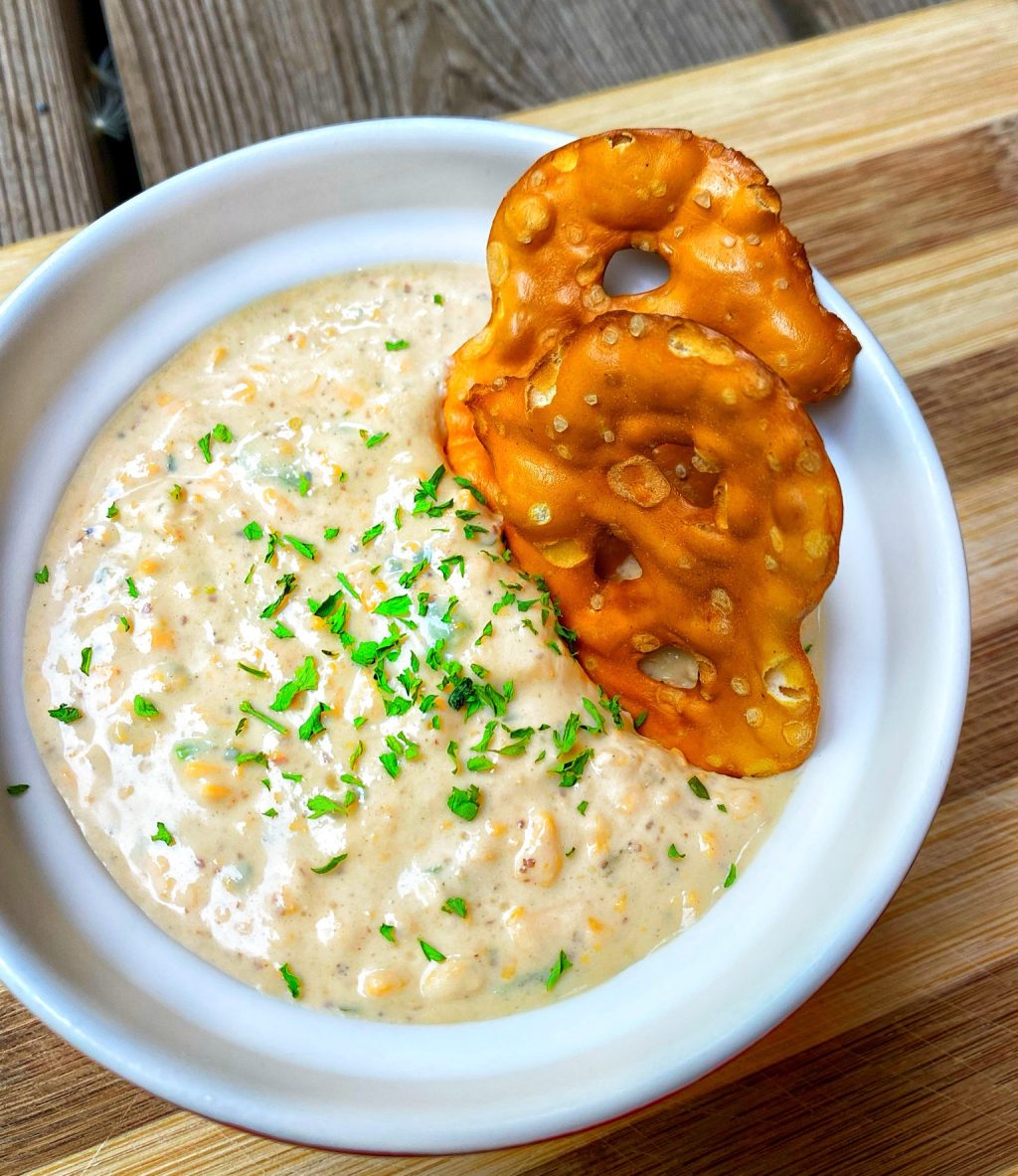 Two pretzel chips dipped in the beer cheese dip