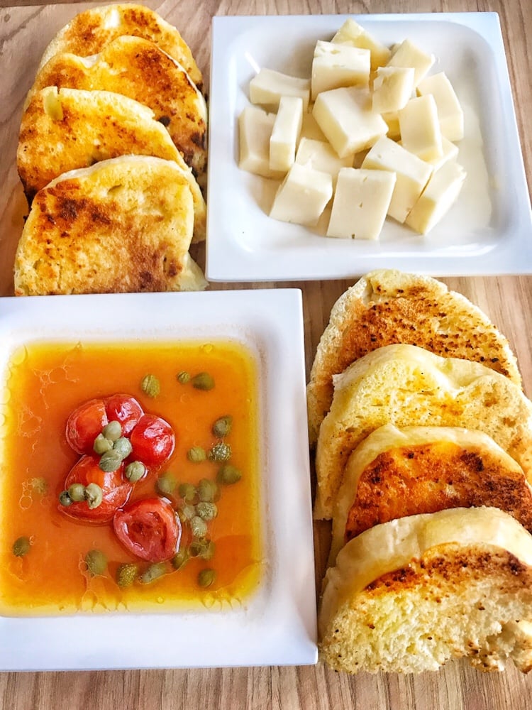 Tomato Infused olive oil dip with cheese and toasted bread dumplings on the side