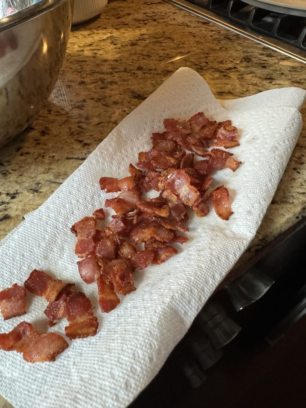 Diced bacon on a paper towel on a kitchen counter