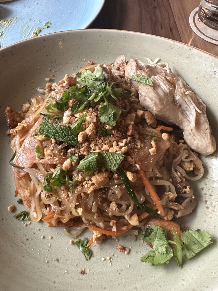 Asian style noodles with meat, peanuts, carrots, onion, and basil