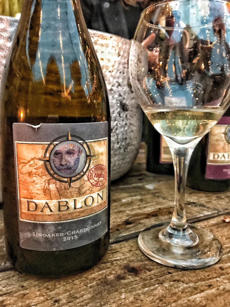 A bottle of Dablon Chardonnay next to a glass with white wine