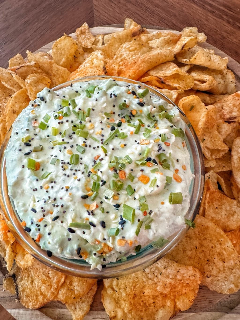 Smoked salmon dip in a glass bowl surrounded by BBQ chips