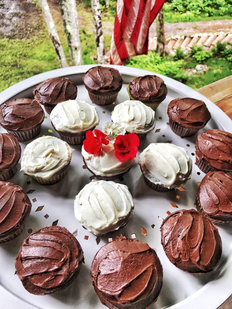 Frosted chocolate cupcakes on a white platter.