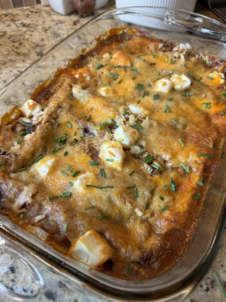 Chili cheese dip enchiladas in a glass baking dish.