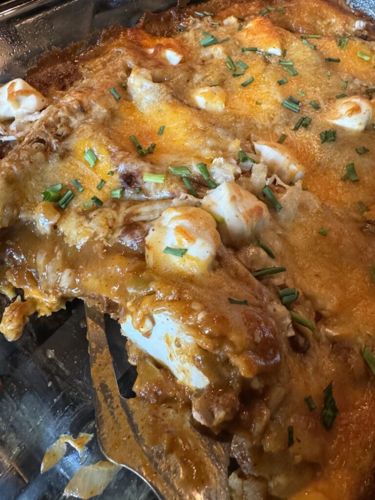 A close up of the baked chili cheese dip enchiladas.