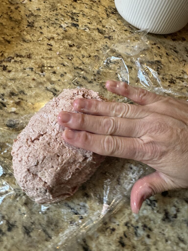 A picture of my hand molding the liver sausage dip.