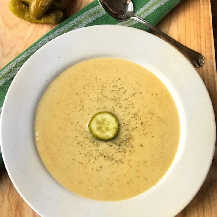 Dill pickle soup with a dill pickle chip in the center.