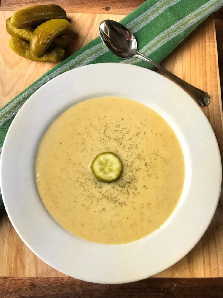 Dill pickle soup with a dill pickle chip in the center.