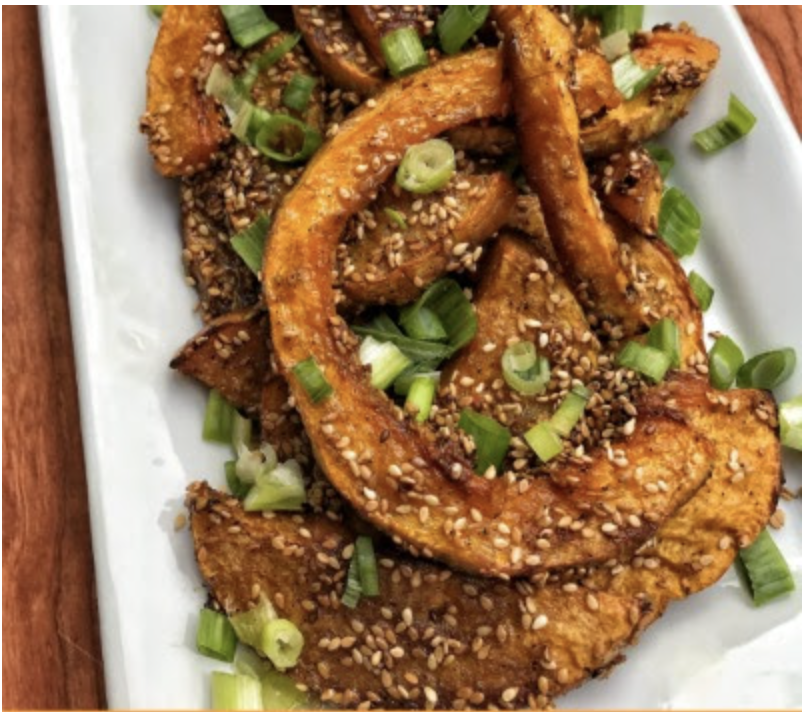 Candied butternut squash slices with sesame seeds and green onions.