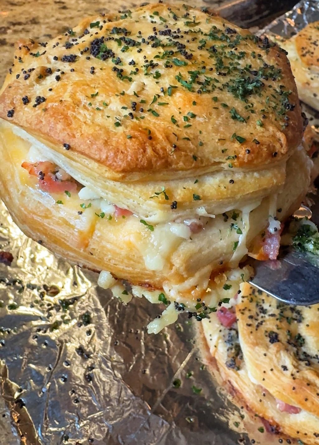 A ham and cheese biscuit puff on a spatula.
