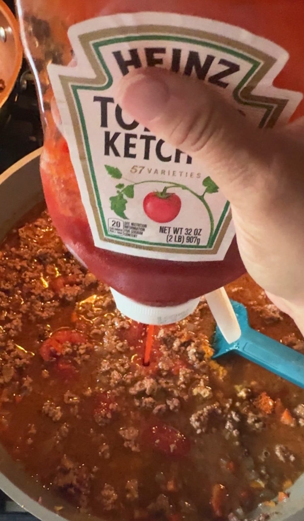 Ketchup being squirted into the BBQ beef mixture.