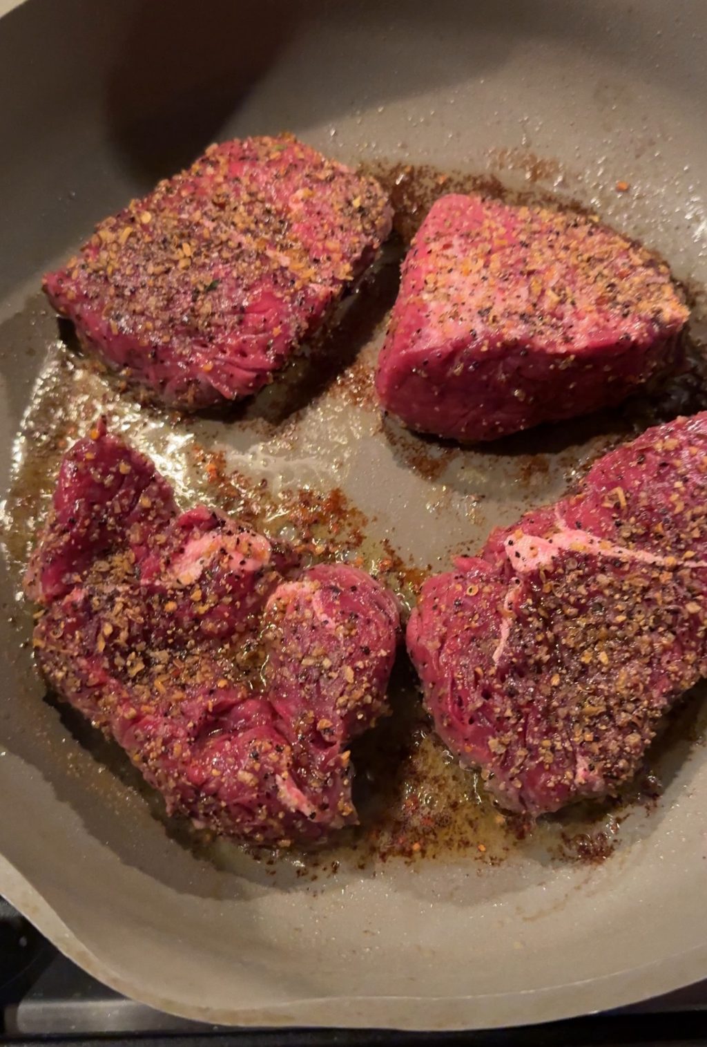 Seasoned sirloin filets cooking in the pan.