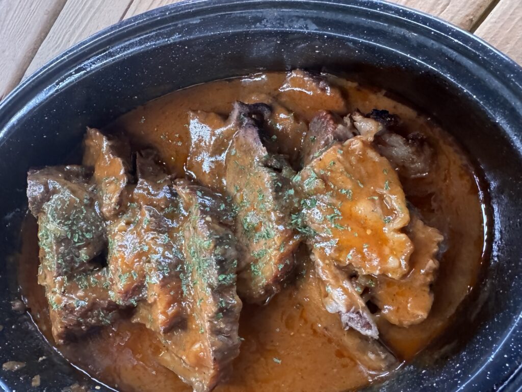 The beef roast slices in a roasting dish in sauce.