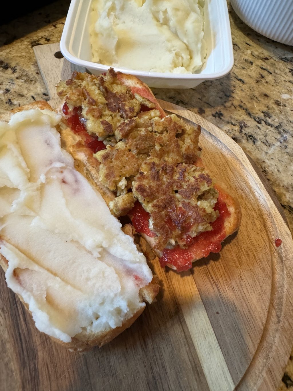 The two halves of the stuffing sandwich, with mashed potatoes spread on one side and the crispy stuffing and cranberry sauce on the other.