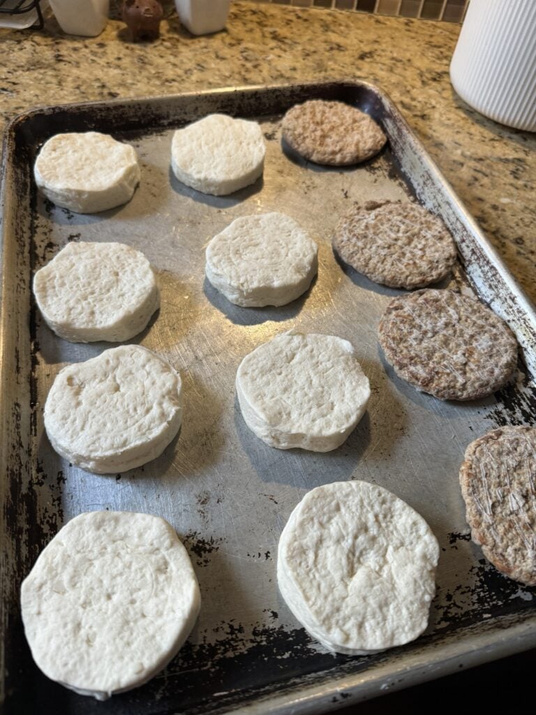 Frozen biscuits and sausage patties on a baking sheet