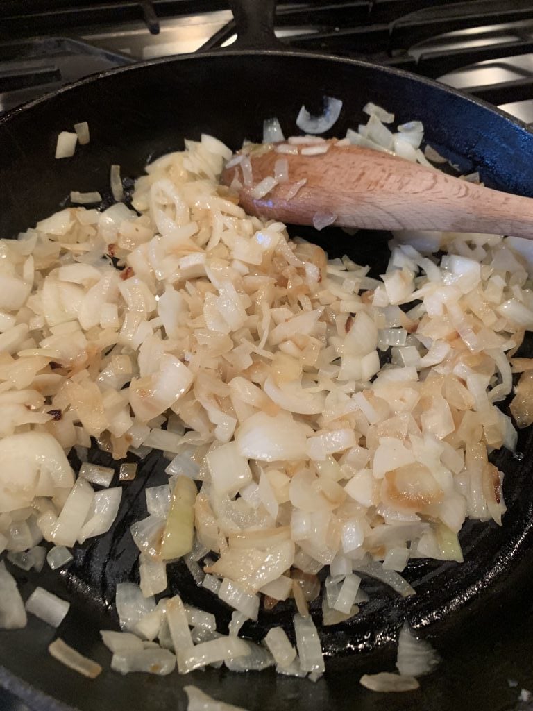 Onions sautéing in a skillet.