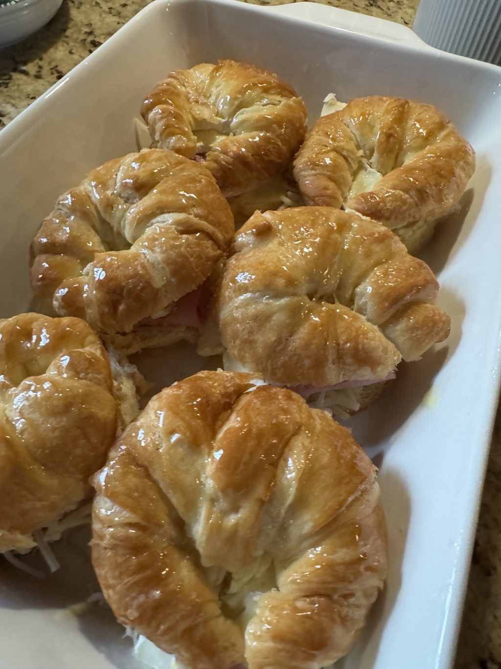 The baked croissant sandwiches in a baking dish.