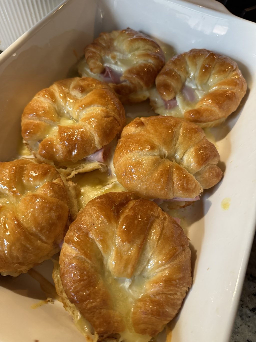 The baked croissant sandwiches in a baking dish.