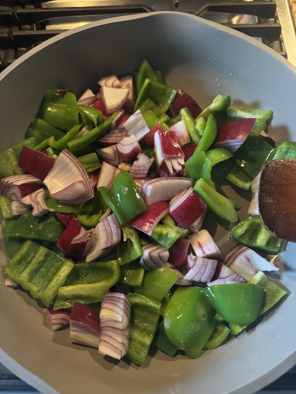 Peppers and onions cooking in a pan