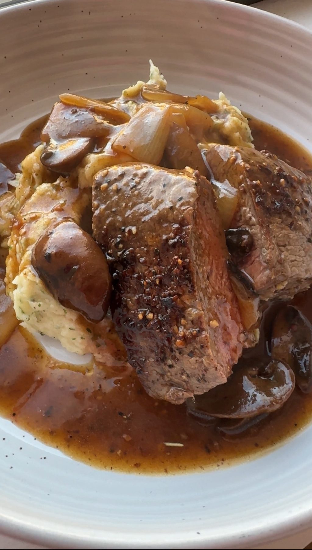 Close up of the finished sirloin medallions with potatoes and onions covered in mushroom gravy