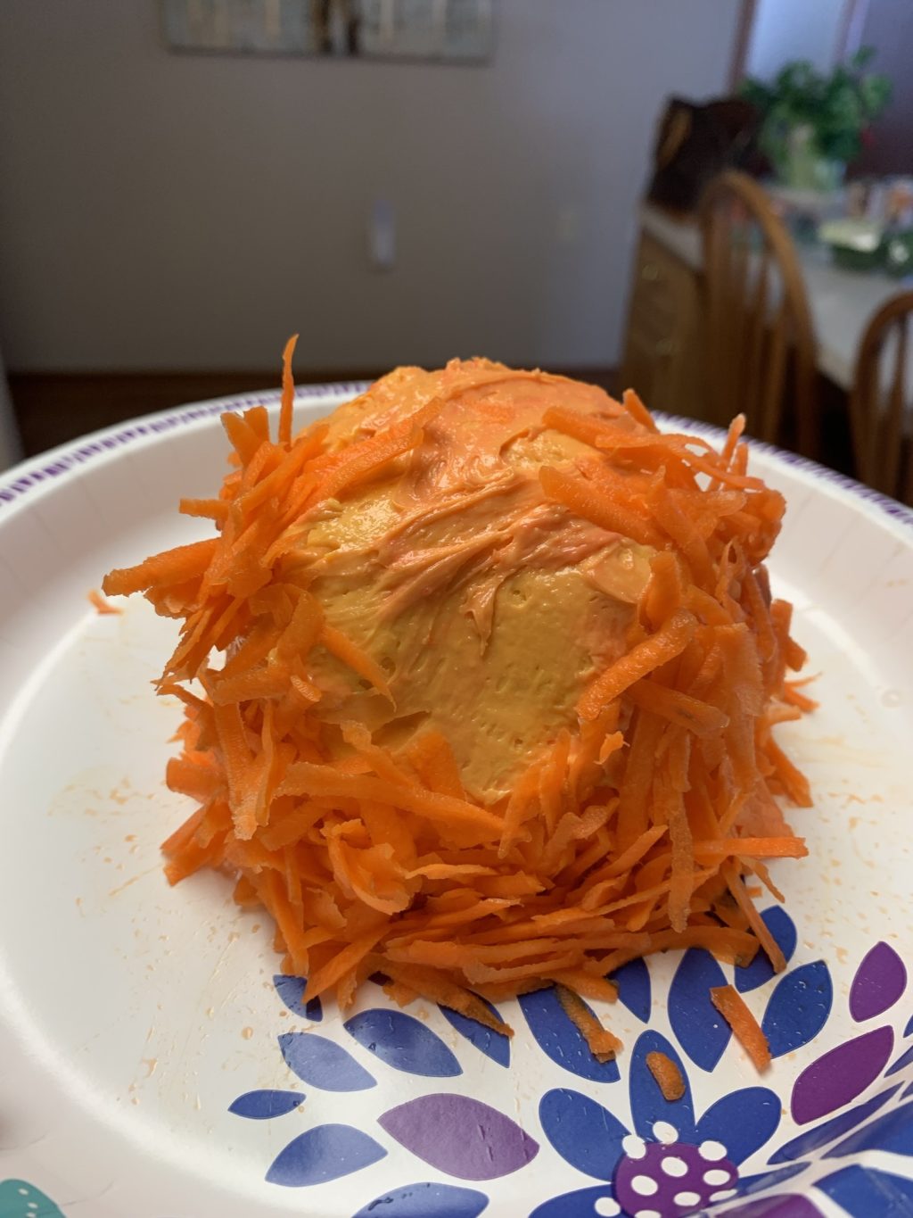 The cheese ball with shredded carrots on it