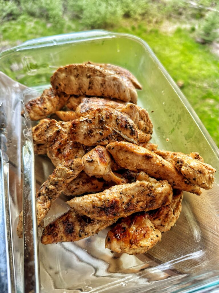 The finished grilled chicken in a glass baking dish
