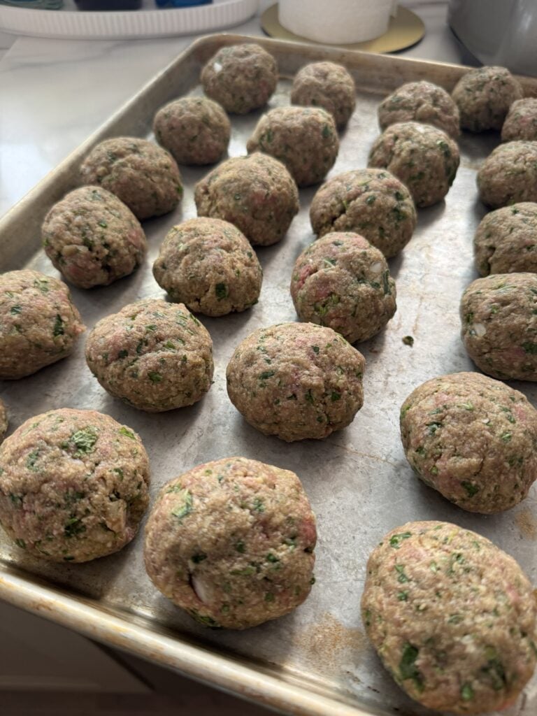 The meatballs on a baking sheet before cooking