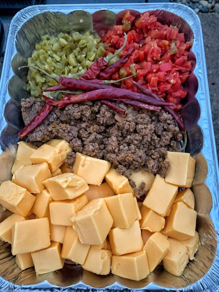 Cubed cheese, ground meat, chili peppers, and diced tomatoes