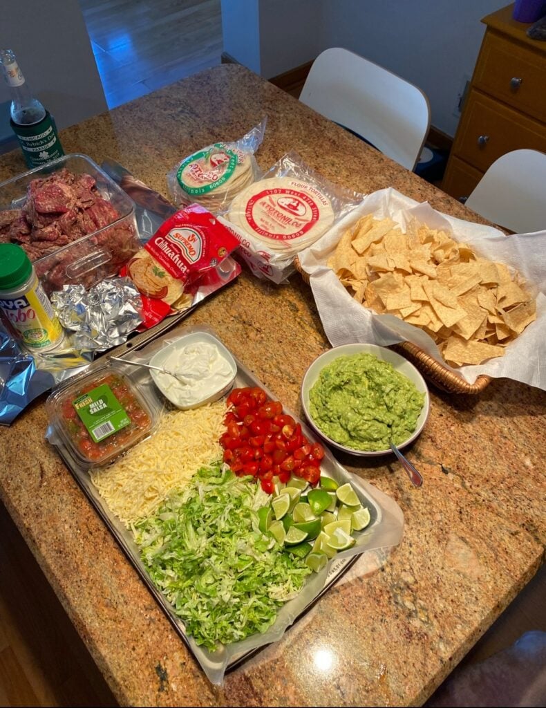 The full chip and topping bar with tortillas to enjoy with the queso