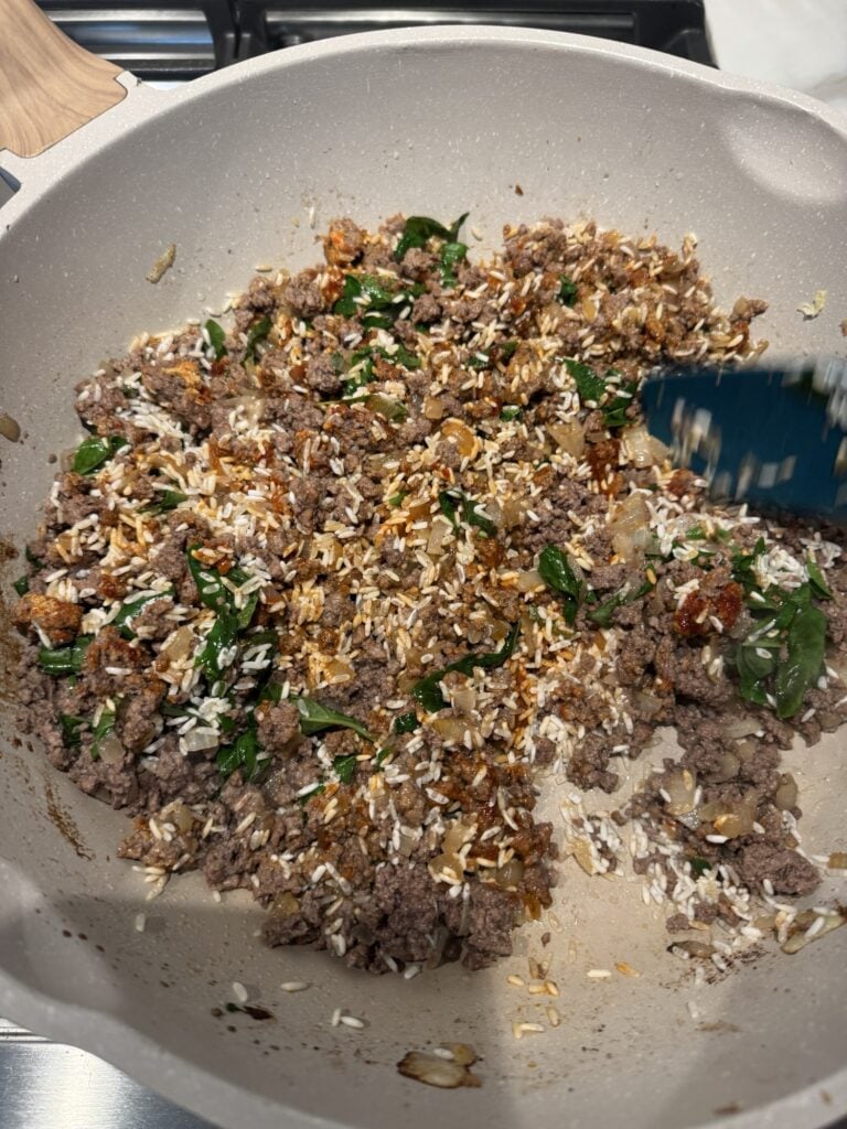 The ground beef and rice mixture cooking in the pan