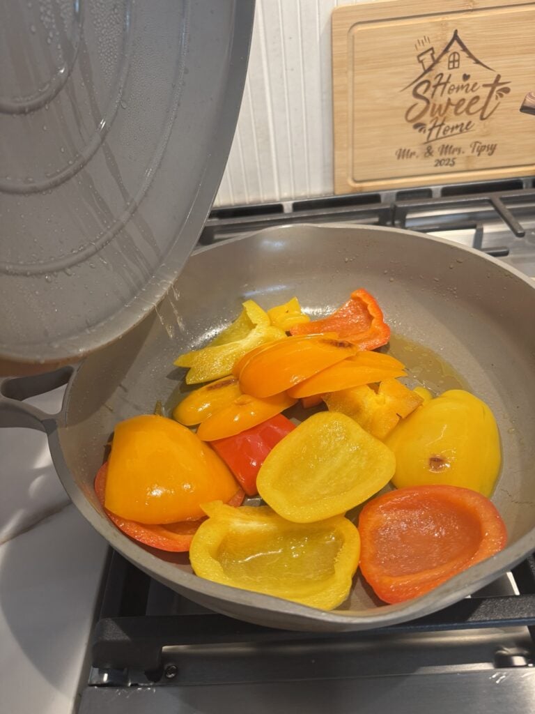 Sliced bell peppers in a pan with oil
