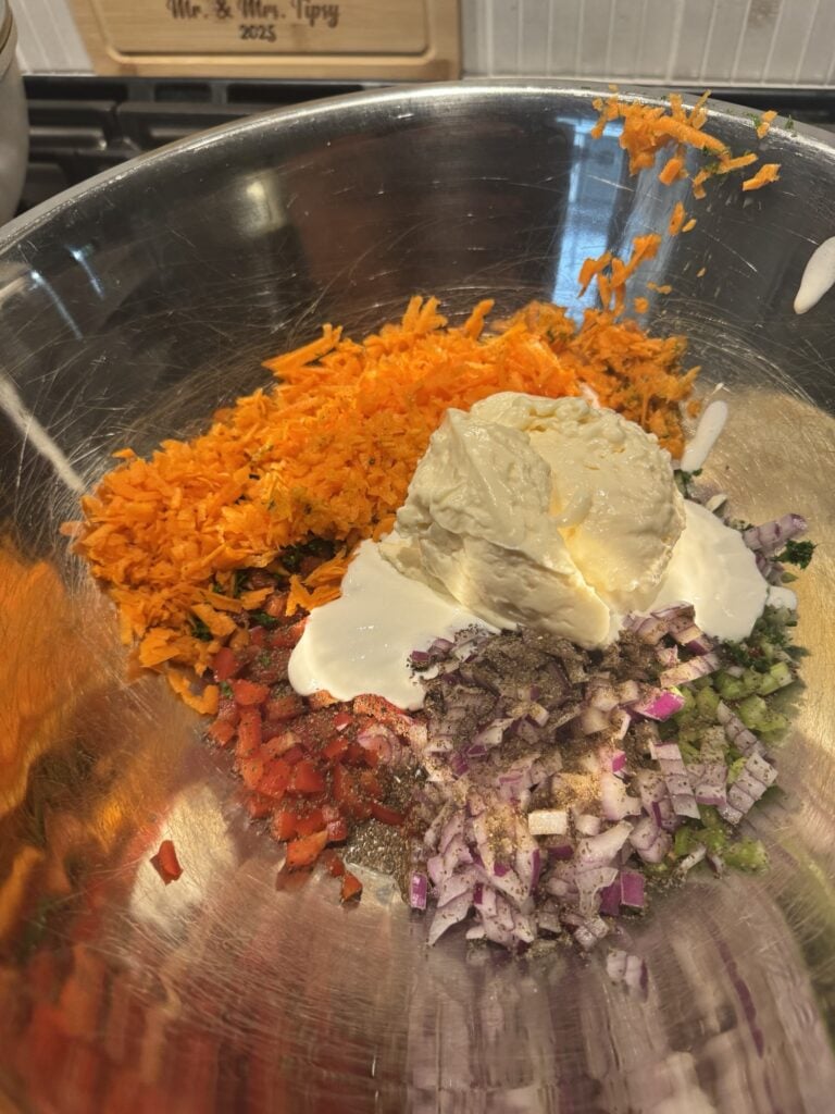 Mayo and crema over the diced veggies in a meta bowl