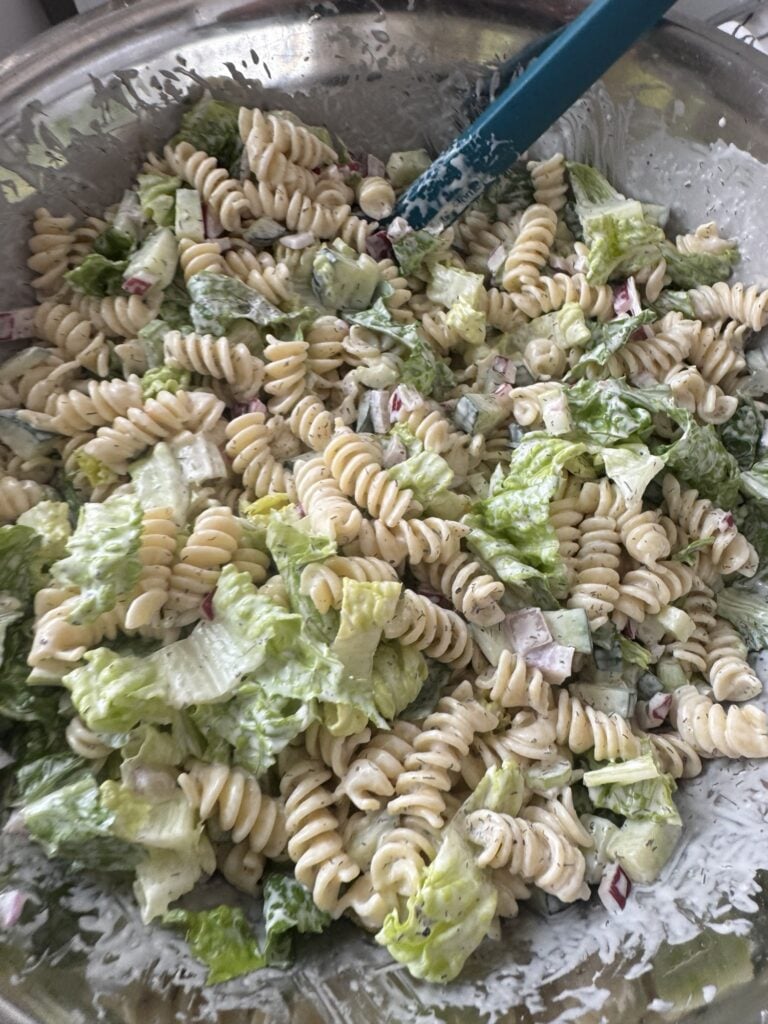 A close up of the pasta salad all mixed up with the veggies and dressing