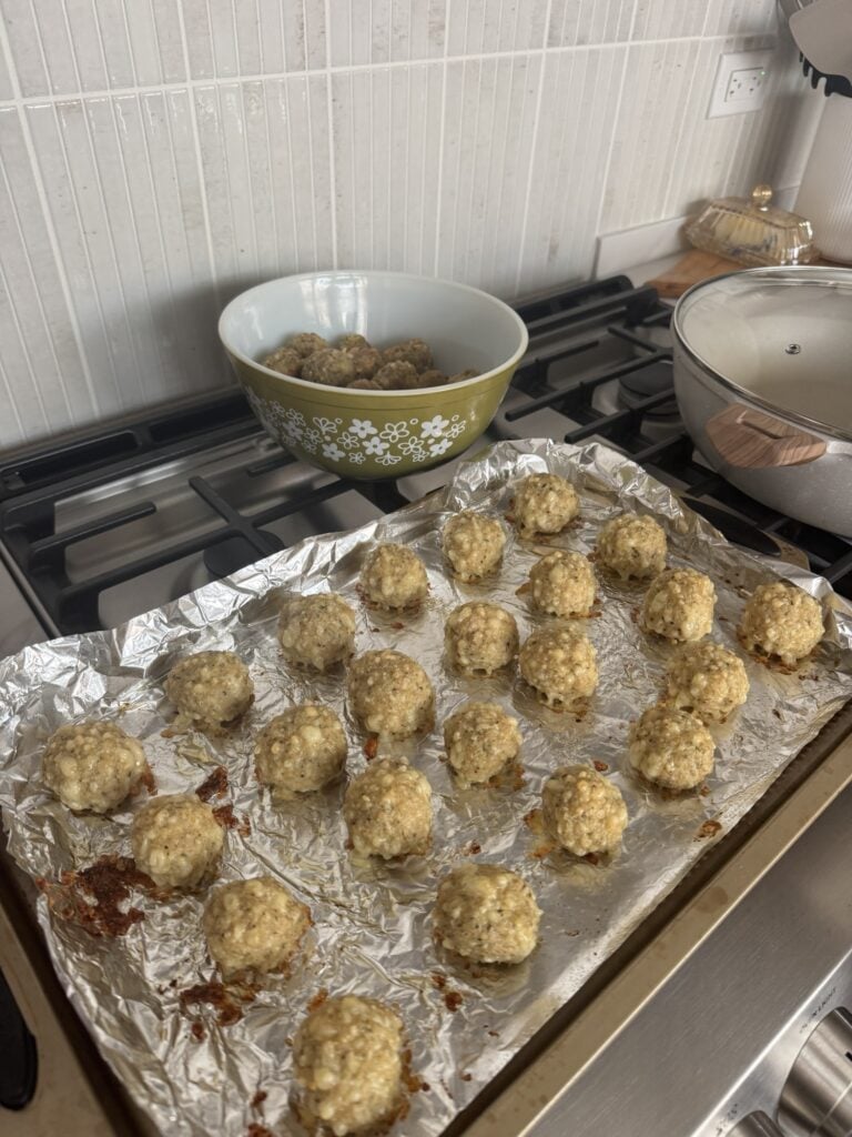 The meatballs spread out on a baking sheet