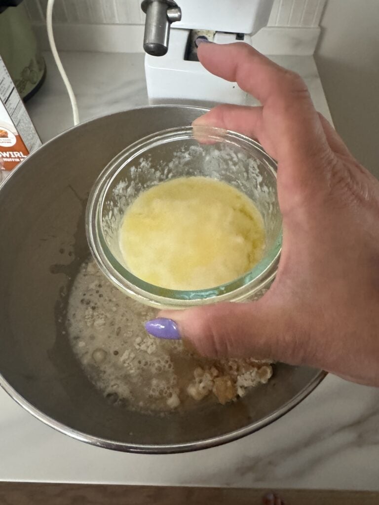 Melted butter in a small glass container over the over the cake mix
