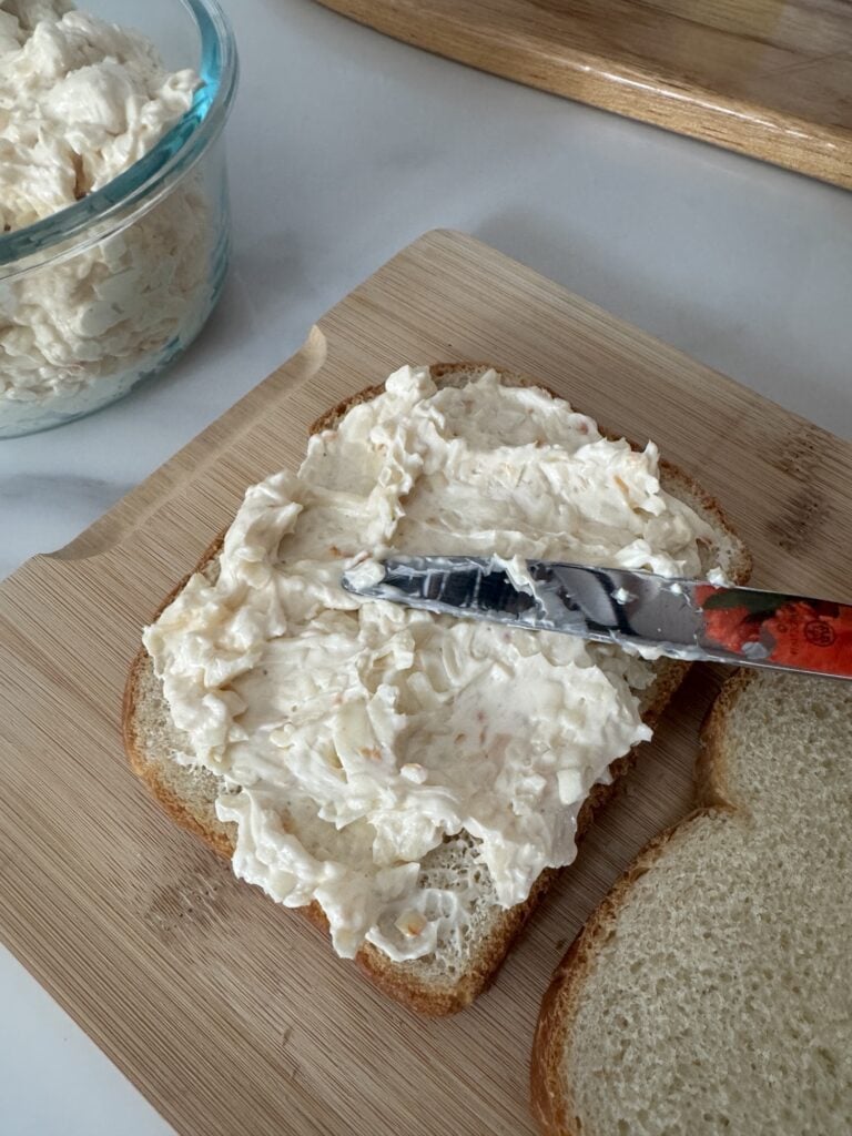 Cheese spread being spread on bread