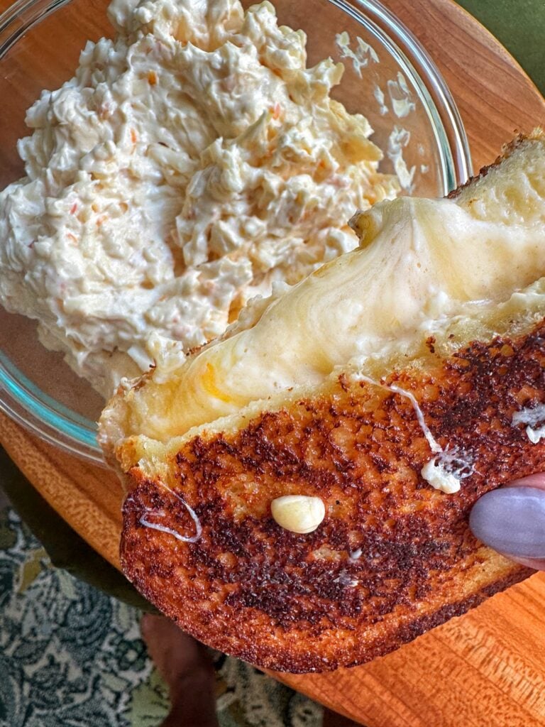 Grilled cheese sandwich over a bowl of grilled cheese spread