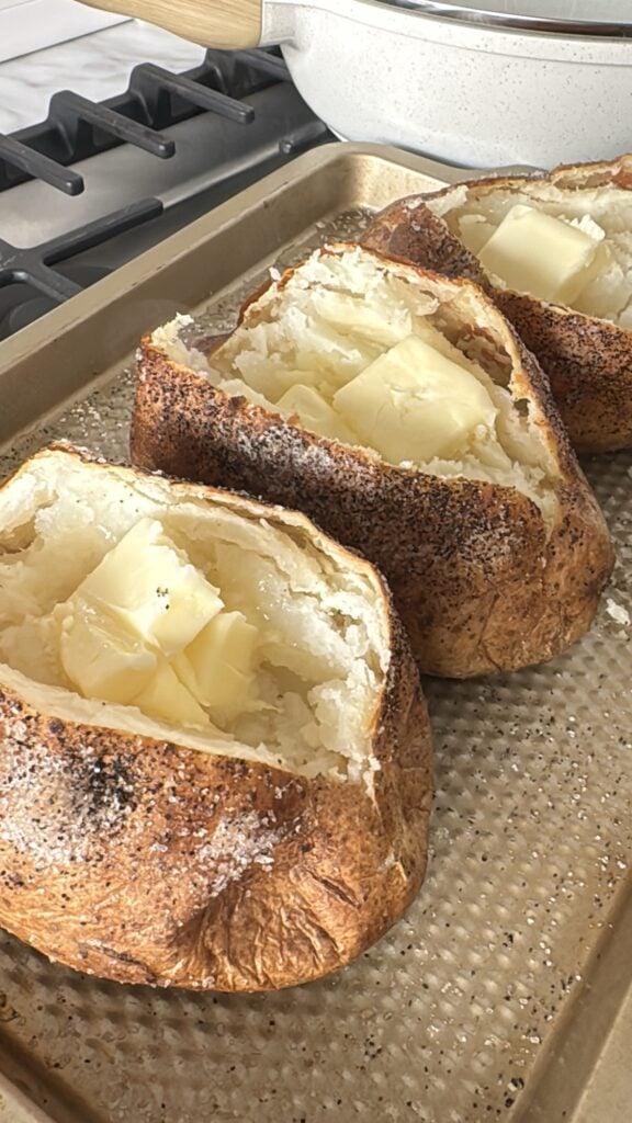 Baked potatoes split open with butter pats