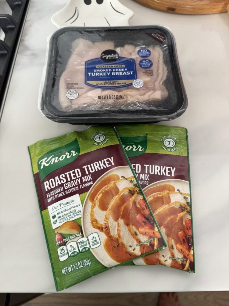 A package of deli turkey and two packets of roasted turkey gravy