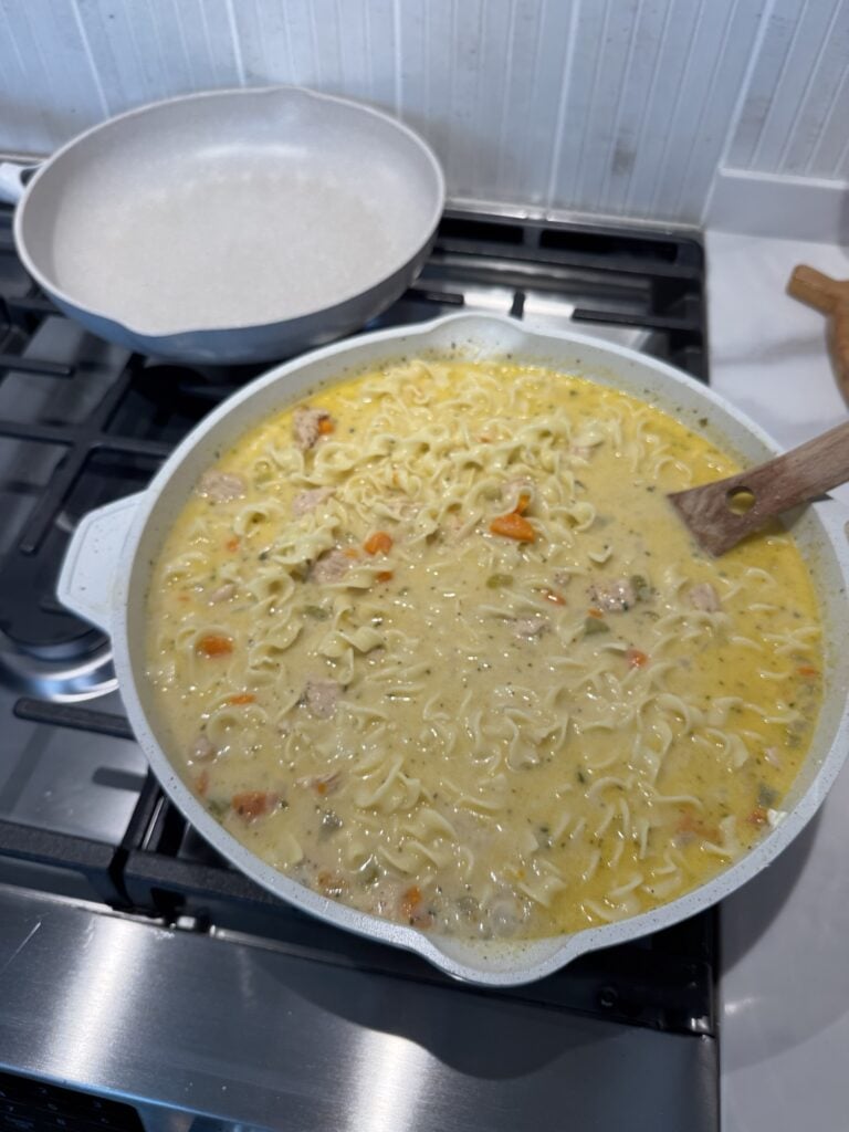 Chicken and noodles simmering in the pan