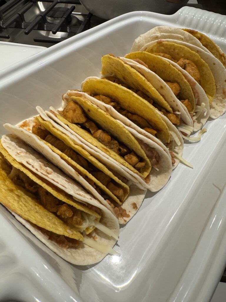 A row of tacos in a baking dish