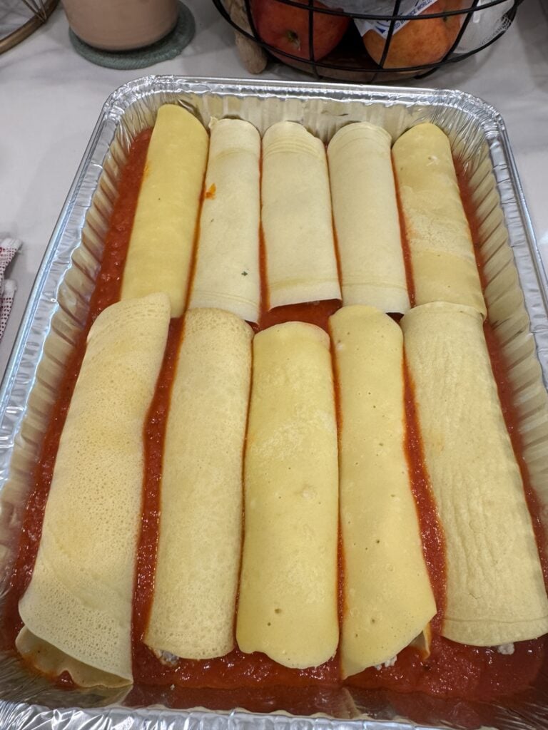 Crepe Style Manicotti in the pan with sauce before baking