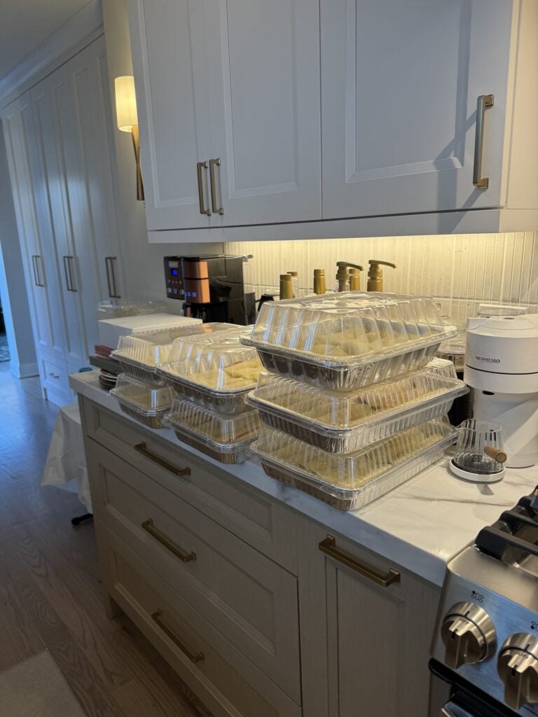 Seven covered pans of manicotti on the counter