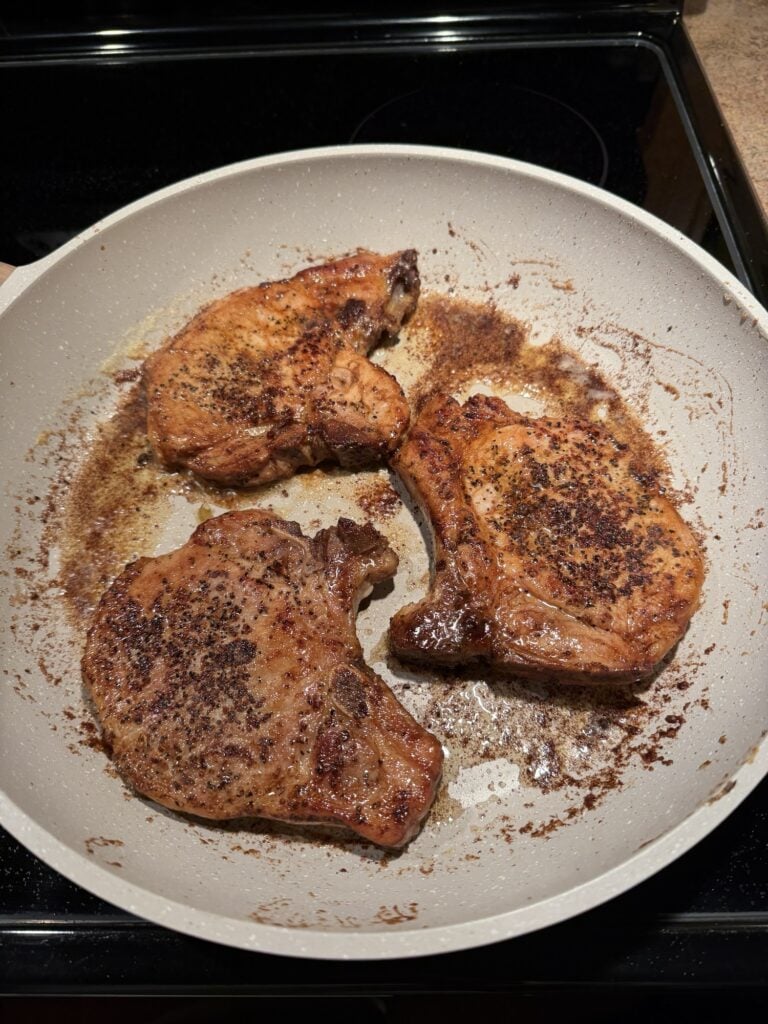 Pork chops cooking in the pan