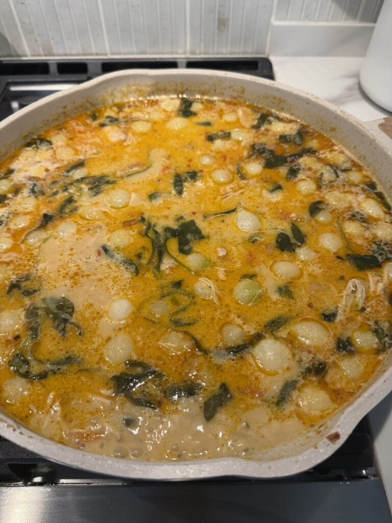 The simmering soup with vegetables in it