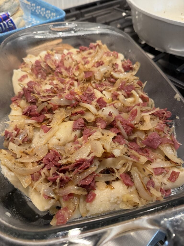 Shredded corned beef and sauerkraut over pierogis