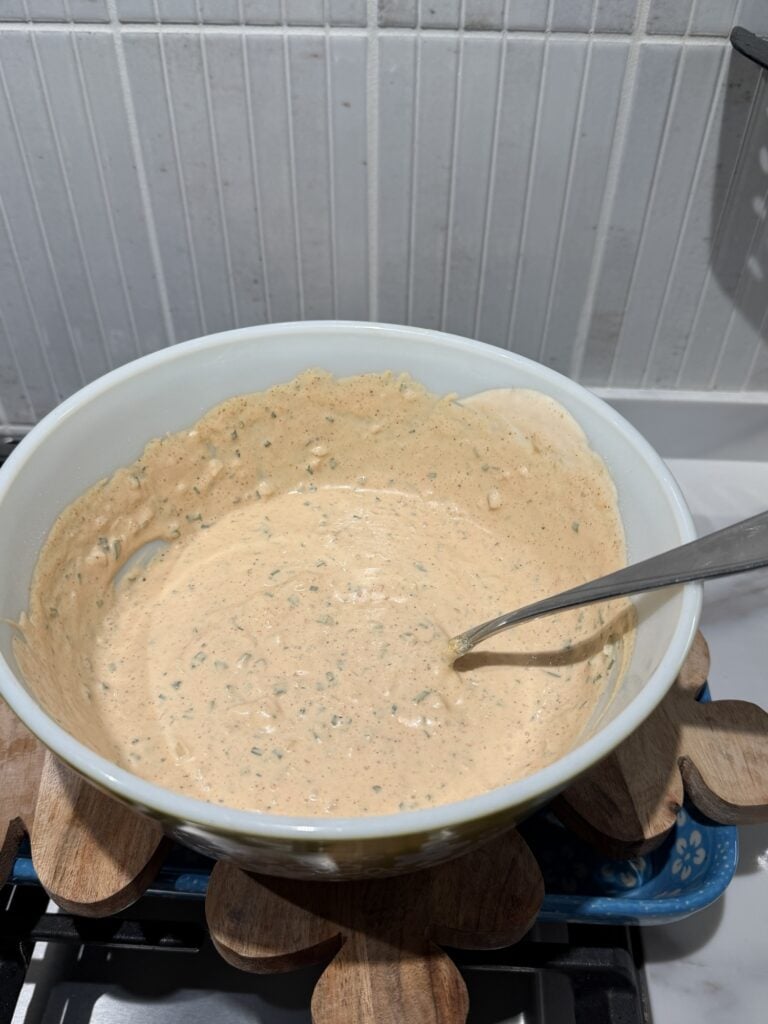 The dip in a big bowl with a big spoon