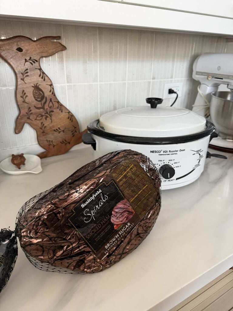A packaged ham next to a Nesco Roaster Oven
